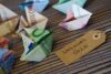 Origami mit Euro-Banknoten neben einem Etikett mit der Aufschrift „Urlaubsgeld“ auf gewebtem Hintergrund, das innovative Humanressourcen-Strategien symbolisiert.
