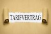 Zerrissenes Papier, auf dem das Wort „tarifvertrag“ zu sehen ist, was auf Englisch „Tarifvertrag“ oder „Arbeitsvertrag“ bedeutet, was auf einen Schwerpunkt auf Arbeitsrechten, Verhandlungen oder gewerkschaftsbezogenen Themen hindeutet.