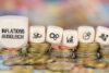 Stapel von Münzen in aufsteigender Reihenfolge mit darauf liegenden Würfeln mit Wirtschaftssymbolen und dem deutschen Wort „Inflationsausgleich“, das Finanzstrategien und Wirtschaftskonzepte symbolisiert.