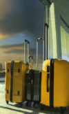Drei Koffer unterschiedlicher Größe, mit einem Farbverlauf von Gelb nach Schwarz, stehen neben einer Säule, möglicherweise an einem Flughafen oder einem Reiseknotenpunkt, und warten darauf, eine Reise anzutreten.