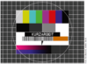 Eine Fernsehtestkarte mit verschiedenen Farben und Mustern, in deren Mitte deutlich sichtbar das Wort „Kurzarbeit“ zu sehen ist.