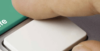 Nahaufnahme einer Fingerspitze, die gerade dabei ist, eine Taste auf einer Computertastatur zu drücken.