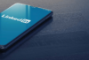 Ein Smartphone liegt auf einer dunklen strukturierten Oberfläche und zeigt auf dem Bildschirm das LinkedIn-Logo für Personalmanagement und Humanressourcen.