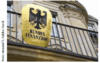 Ein Schild mit einem schwarzen Adler auf gelbem Hintergrund und der Aufschrift „Bundesfinanzhof“ ist an der Außenseite eines klassischen Steingebäudes angebracht und weist auf den Standort des Bundesfinanzgerichts in Deutschland hin.