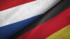 Ein Bild, das die Verschmelzung der russischen und deutschen Flaggen zeigt und eine Mischung der Symbole der beiden Nationen auf einem strukturierten Stoffhintergrund darstellt.