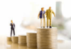 Die Miniaturfigur eines Geschäftsmannes steht auf einem kleinen Stapel Münzen, während zwei ältere Figuren mit einem Stock auf größeren Stapeln stehen und so finanzielles Wachstum oder die Planung für den Ruhestand symbolisieren. Der Hintergrund ist unscharf und hell.