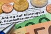 Euro-Münzen und Banknoten auf einem Antragsformular für Elterngeld („Elterngeld“) mit einem Stift, symbolisieren die Finanzplanung der Familie in Deutschland.
