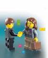 Zwei LEGO-Figuren geben sich die Hand. Die Figur links hat kurzes braunes Haar und trägt einen schwarzen Anzug. Die Figur rechts hat langes braunes Haar, trägt einen grauen Anzug und trägt eine braune Aktentasche. Um sie herum sind verschiedene bunte LEGO-Steine verstreut.