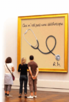 Drei Personen stehen in einer Kunstgalerie und betrachten ein großes gerahmtes Kunstwerk, das ein Stethoskop zeigt. Darüber steht „Ceci n'est pas une stéthoscope“ („Das ist kein Stethoskop“). Die Initialen „R.M.“ stehen in der unteren rechten Ecke.
