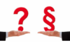 Zwei Hände sind nach vorne ausgestreckt und halten jeweils ein großes rotes Symbol. Die linke Hand hält ein Fragezeichen und die rechte Hand ein Abschnittssymbol. Die Symbole sind auf einem schlichten weißen Hintergrund angeordnet.