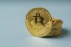 Goldene Bitcoin-Münzen auf hellem Untergrund – Symbolbild für Vergütung in Kryptowährung im Arbeitsverhältnis.