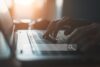 Nahaufnahme von Händen auf einer Laptop-Tastatur mit eingeblendeter Suchleiste – symbolisiert eine Online-Recherche, etwa im Rahmen eines Bewerbungsverfahrens.