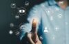 Mann tippt mit seinem Finger auf ein digitales Symbol, es erscheinen viele Symbole aus dem HR- und Payroll-Bereich