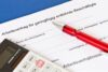 Arbeitsvertrag für geringfügig entlohnte Beschäftigte mit rotem Kugelschreiber und Taschenrechner – symbolisiert neue Minijob-Richtlinien 2026.