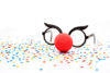 Karnevalsbrille mit roter Nase und buntem Konfetti symbolisiert Karneval im Betrieb und arbeitsrechtliche Regelungen