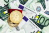 Kryptowährung in der Entgeltabrechnung: Goldene Bitcoin-Münzen auf 100-Euro-Banknoten symbolisieren moderne Vergütungsformen
