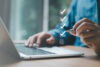 Checkliste EU-Entgelttransparenzrichtlinie: Person arbeitet am Laptop und hakt Aufgaben ab