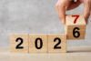 Einkommensteuerreform 2027: Hand dreht Würfel von 2026 auf 2027, symbolisiert Jahreswechsel und neue Steuerregelungen