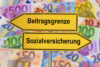 Beitragsbemessungsgrenze und Sozialversicherung – Wegweiser vor Euro-Geldscheinen symbolisiert Rechengrößen 2027