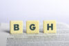 Drei gelbe Würfel mit den Buchstaben B, G und H auf einer Zeitung – symbolisiert BGH-Urteil zum Drittelbeteiligungsgesetz und Schwellenwert für Arbeitnehmer